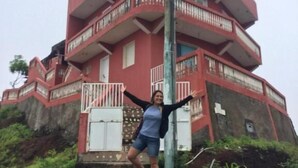 Un edificio a più piani con balconi e una scala che conduce all'ingresso.