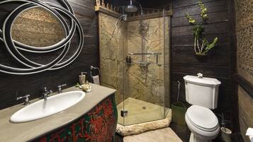 A bathroom with a marble sink, a glass-enclosed shower, and a toilet.