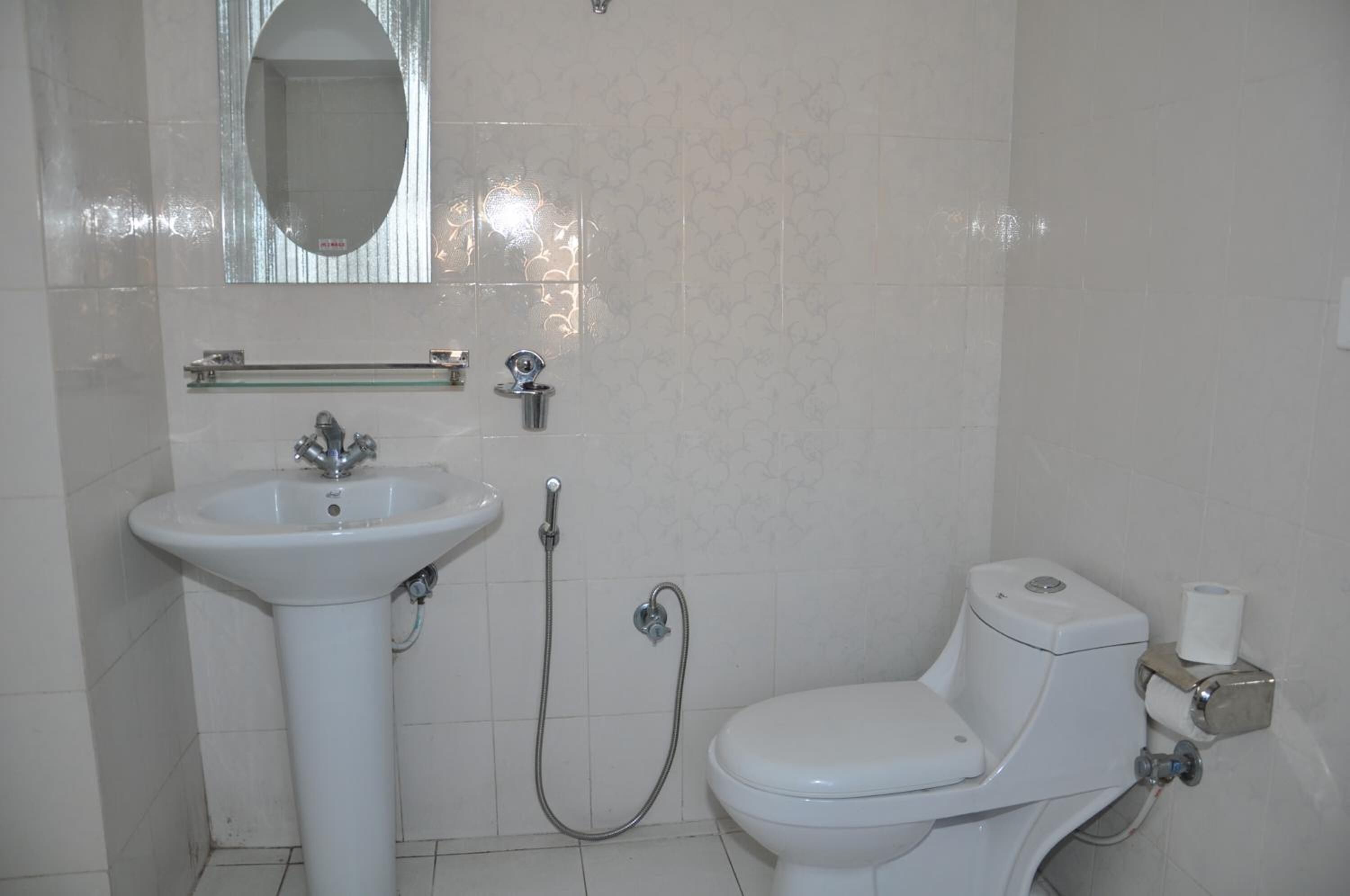 A bathroom with a white sink, toilet, and shower.