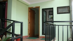 A staircase with a metal railing, a wooden door labeled "Ganesh," and a tiled floor. - Mountain Guest House (Bhaktapur)