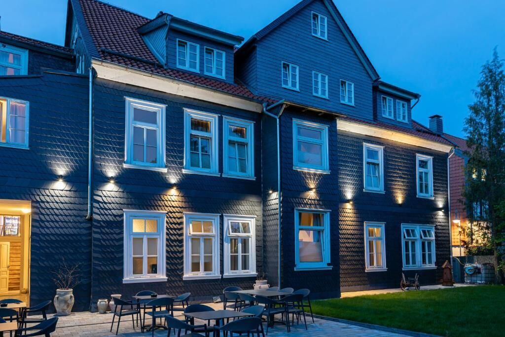 A two-story building with multiple windows and a patio area with outdoor seating.