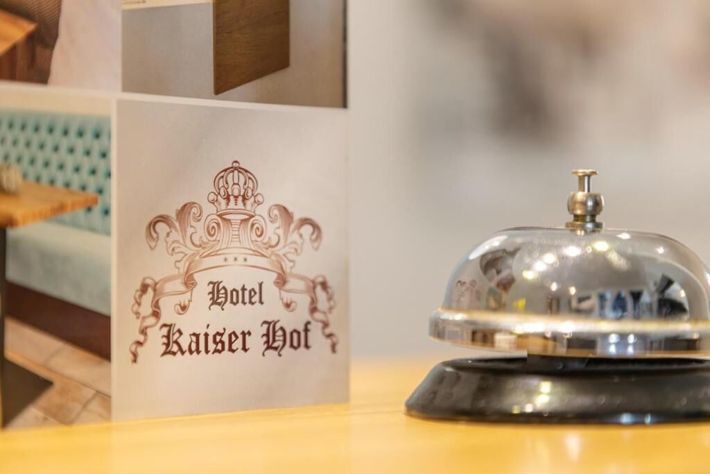 Un letrero de hotel con un diseño clásico y una campana sobre un pedestal.