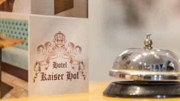 Un letrero de hotel con un diseño clásico y una campana sobre un pedestal.