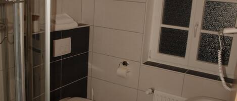 Un baño con inodoro, lavabo y cabina de ducha de vidrio.