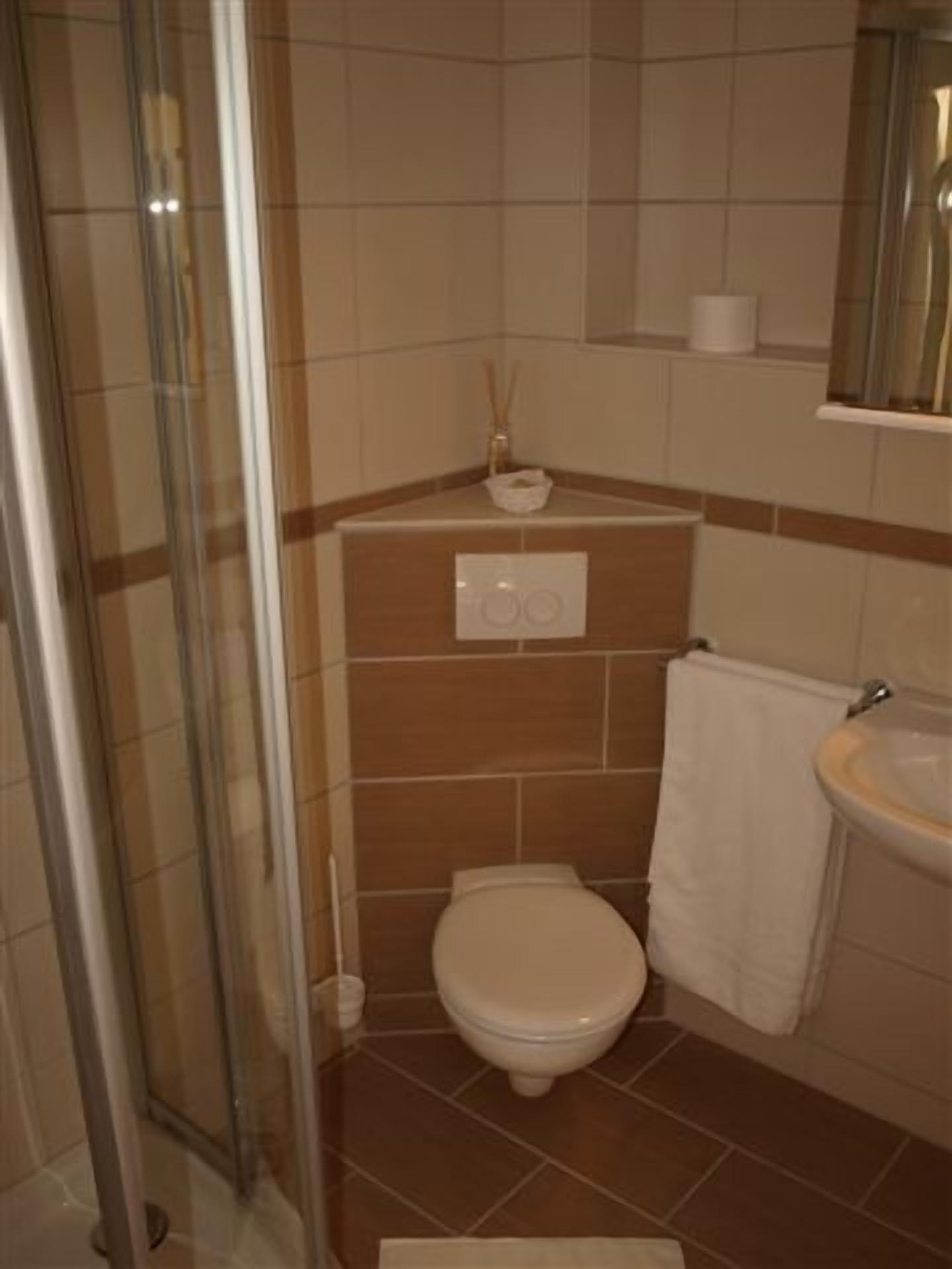 Un baño con inodoro, lavamanos y cabina de ducha de vidrio.