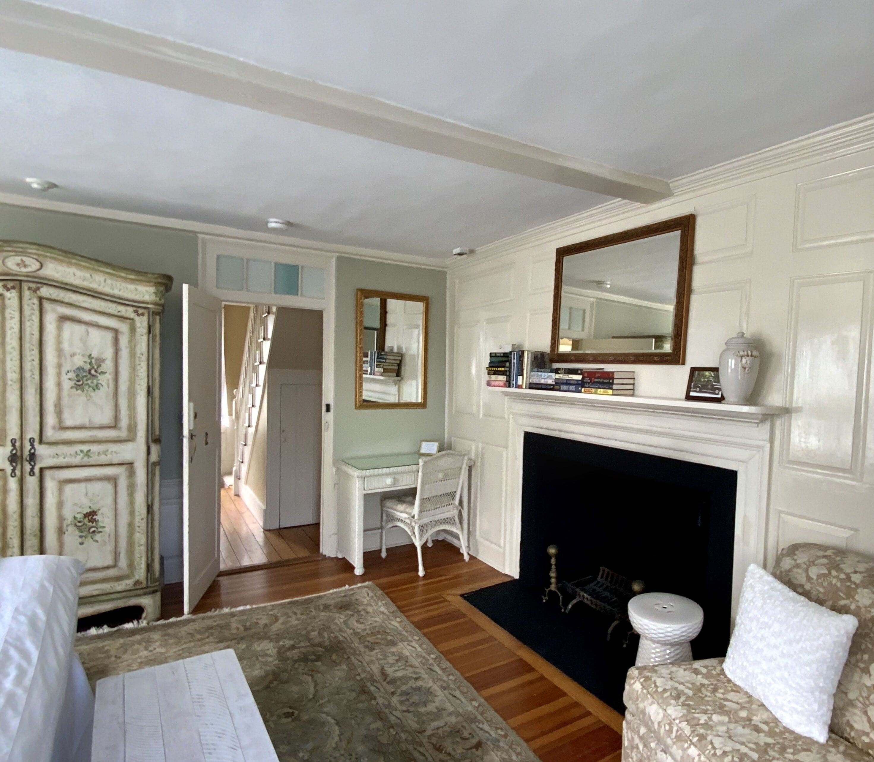 Une pièce avec une cheminée, un bureau, une chaise et un lit.