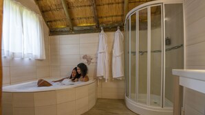 A bathroom with a bathtub, a glass-enclosed shower, and a tiled floor.