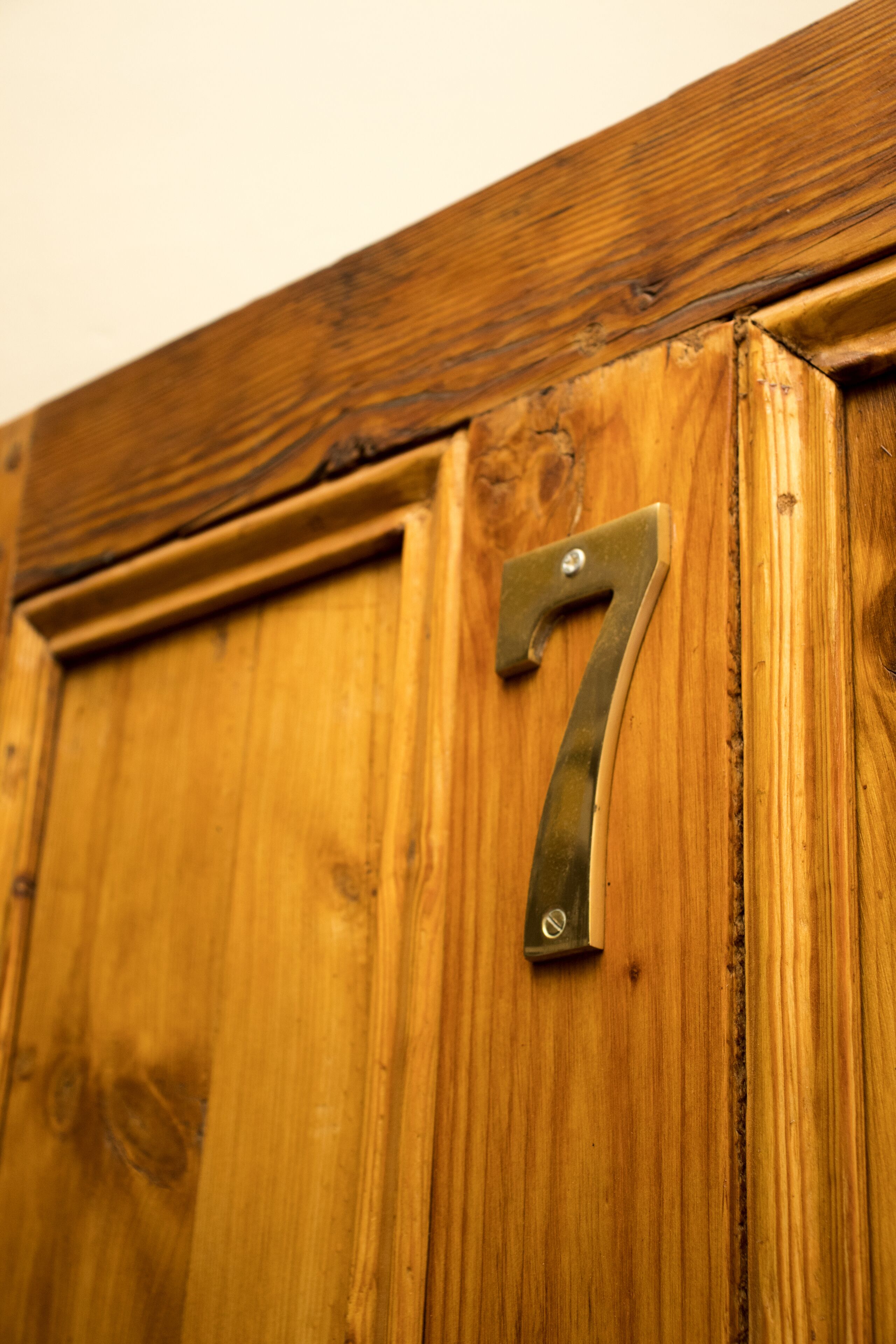 A wooden door with a brass number '7' handle.