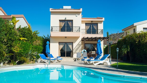 A two-story building with a swimming pool, sun loungers, and umbrellas. - Vineland Holiday Villas (Pissouri)