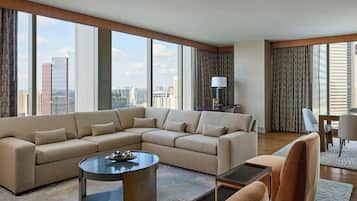 Een moderne woonkamer met een royale zithoek, een rond salontafeltje, en een eethoek met een tafel en stoelen.