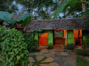 A rustic building with a thatched roof, surrounded by lush greenery. - Khun Nai Tern Sai - Adults Only (Pai)