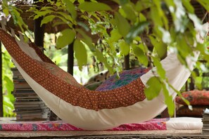 A hammock with a patterned cover, positioned between two cushions on a wooden platform. - Khun Nai Tern Sai - Adults Only (Pai)