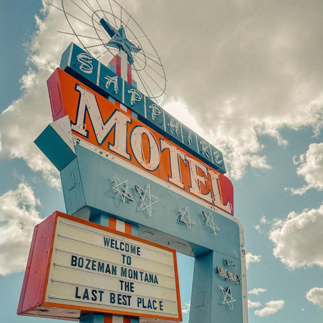 Une enseigne de motel avec les mots « Motel » et « Bienvenue à Bozeman, Montana, le dernier paradis sur terre », le tout sur fond de ciel.