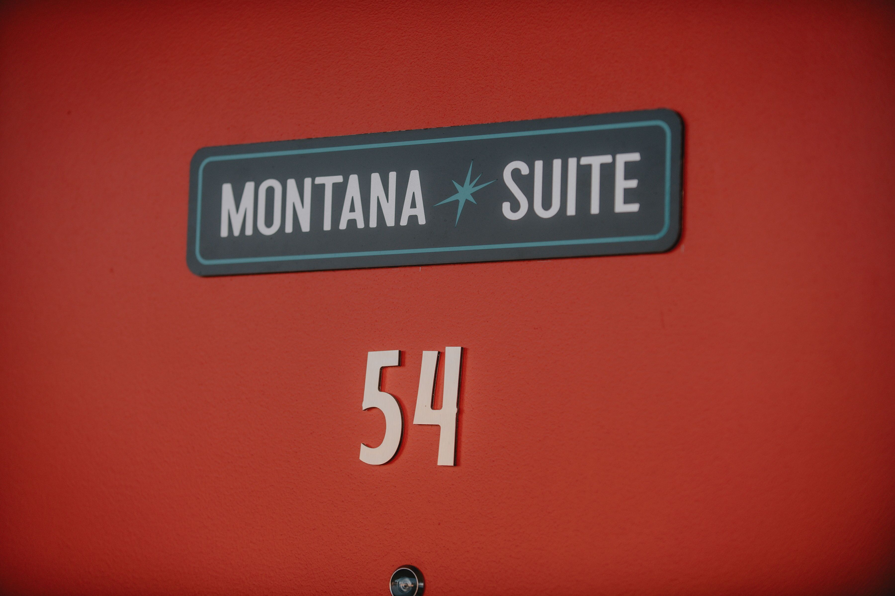 A sign for "MONTANA SUITE 54" on a red wall.