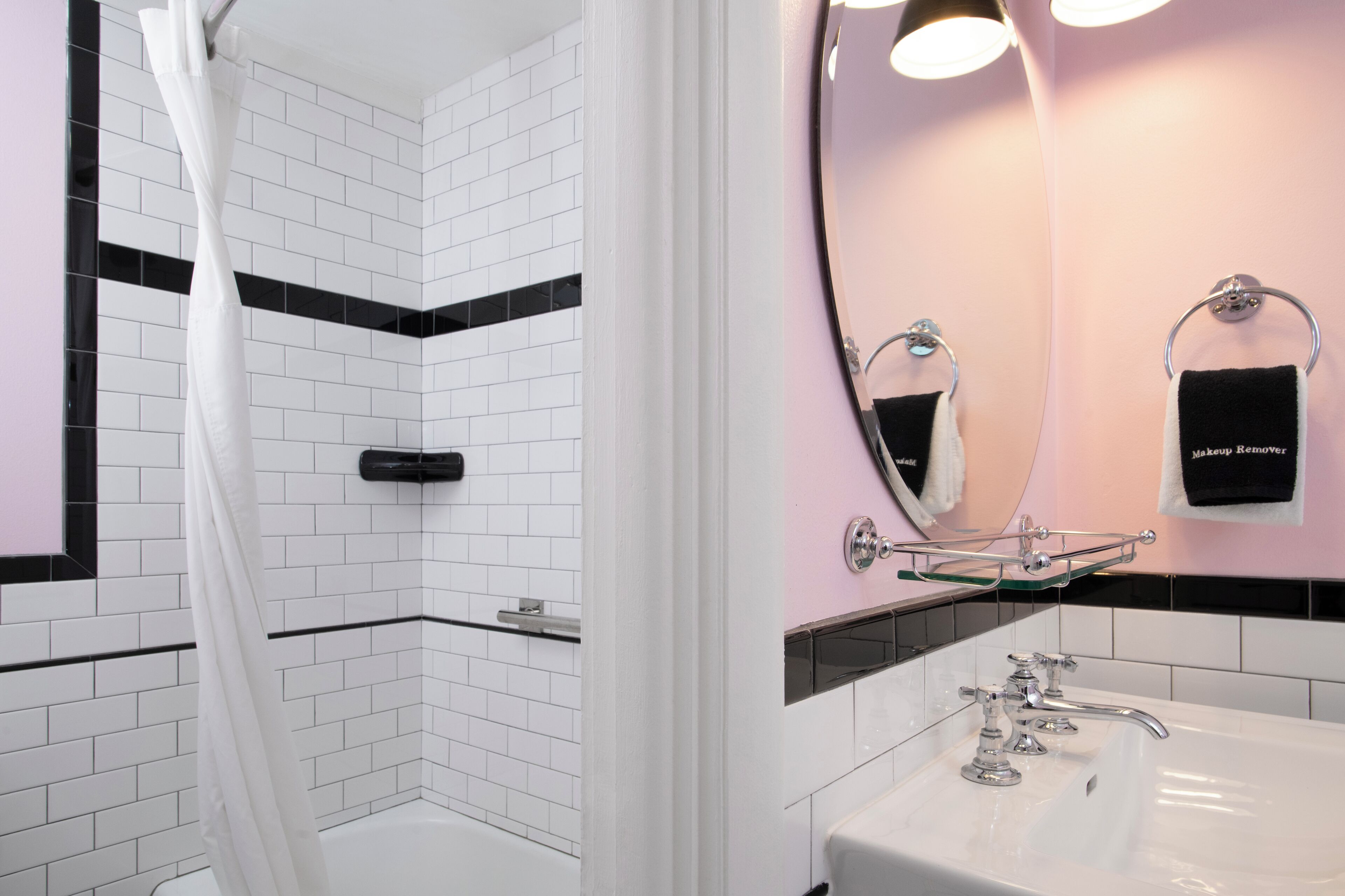 A bathroom with a shower, a sink, and a mirror.