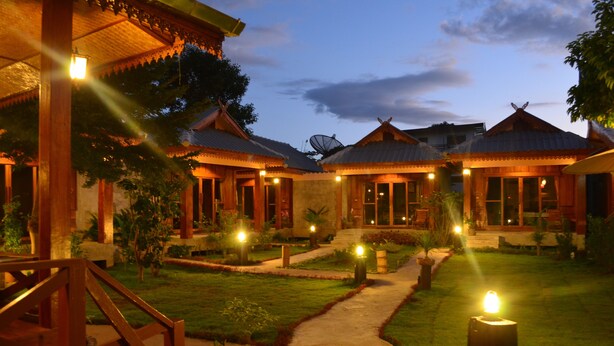A traditional-style building with multiple rooms, a central pathway, and surrounding greenery. - Baan Aew Pai (Pai)