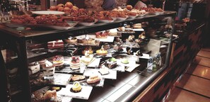A bakery display case with various pastries and desserts. - Seven Roses Hotel (Amman)