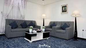 A living room with two grey sofas, a black coffee table, and two floor lamps. - Merfal Serviced Apartments-Royal (Riyadh)