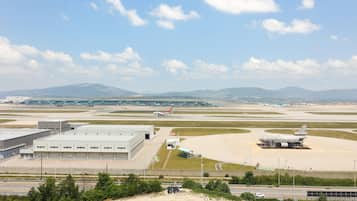 An airport with multiple runways, a large hangar, and a terminal building.
