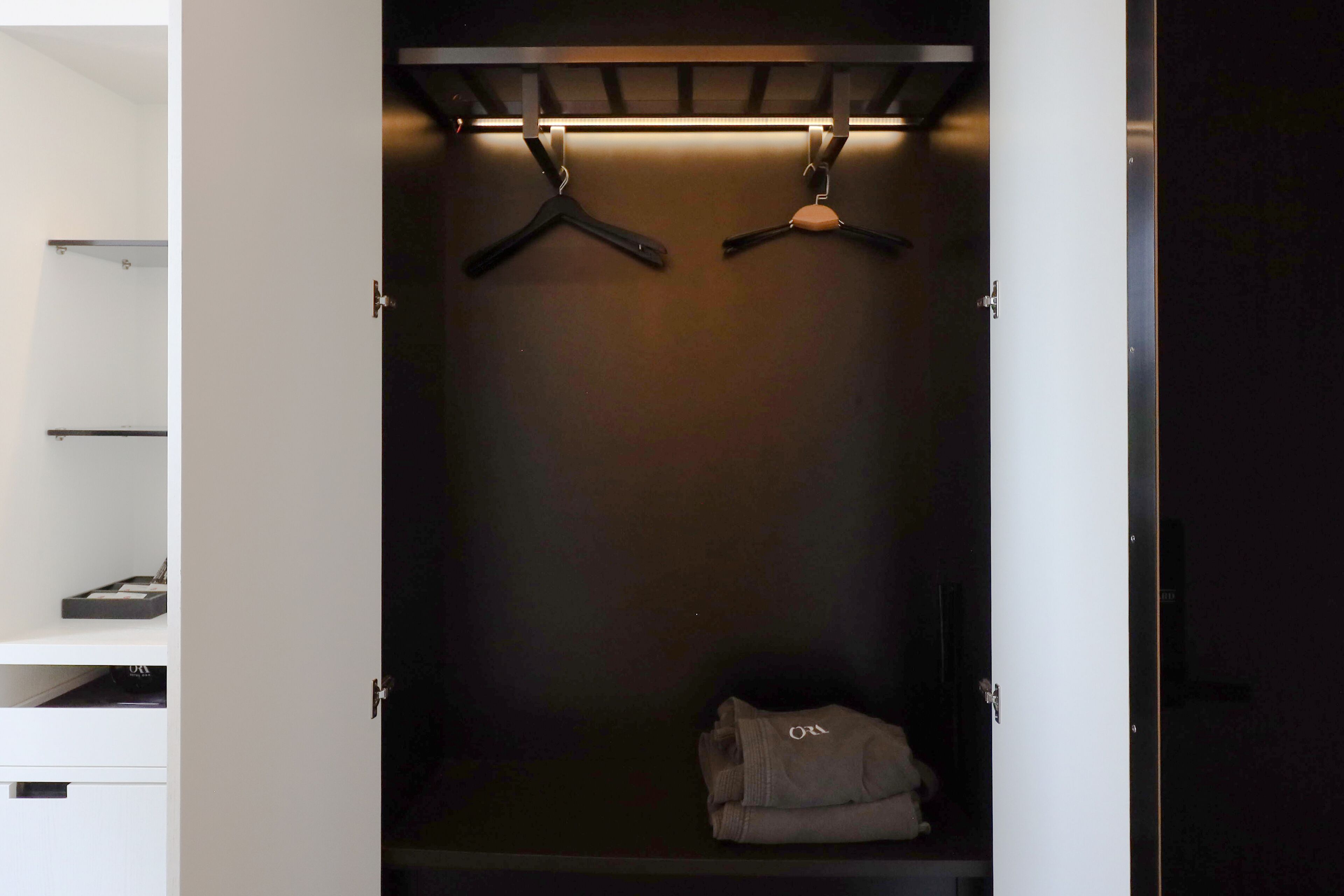 A walk-in closet with a hanging rod and a folded item on the floor.