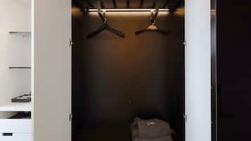 A walk-in closet with a hanging rod and a folded item on the floor.
