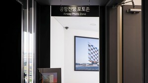 Un pasillo con un cartel que dice 'Airway Photo Zone' y una fotografía enmarcada de un edificio en la pared.