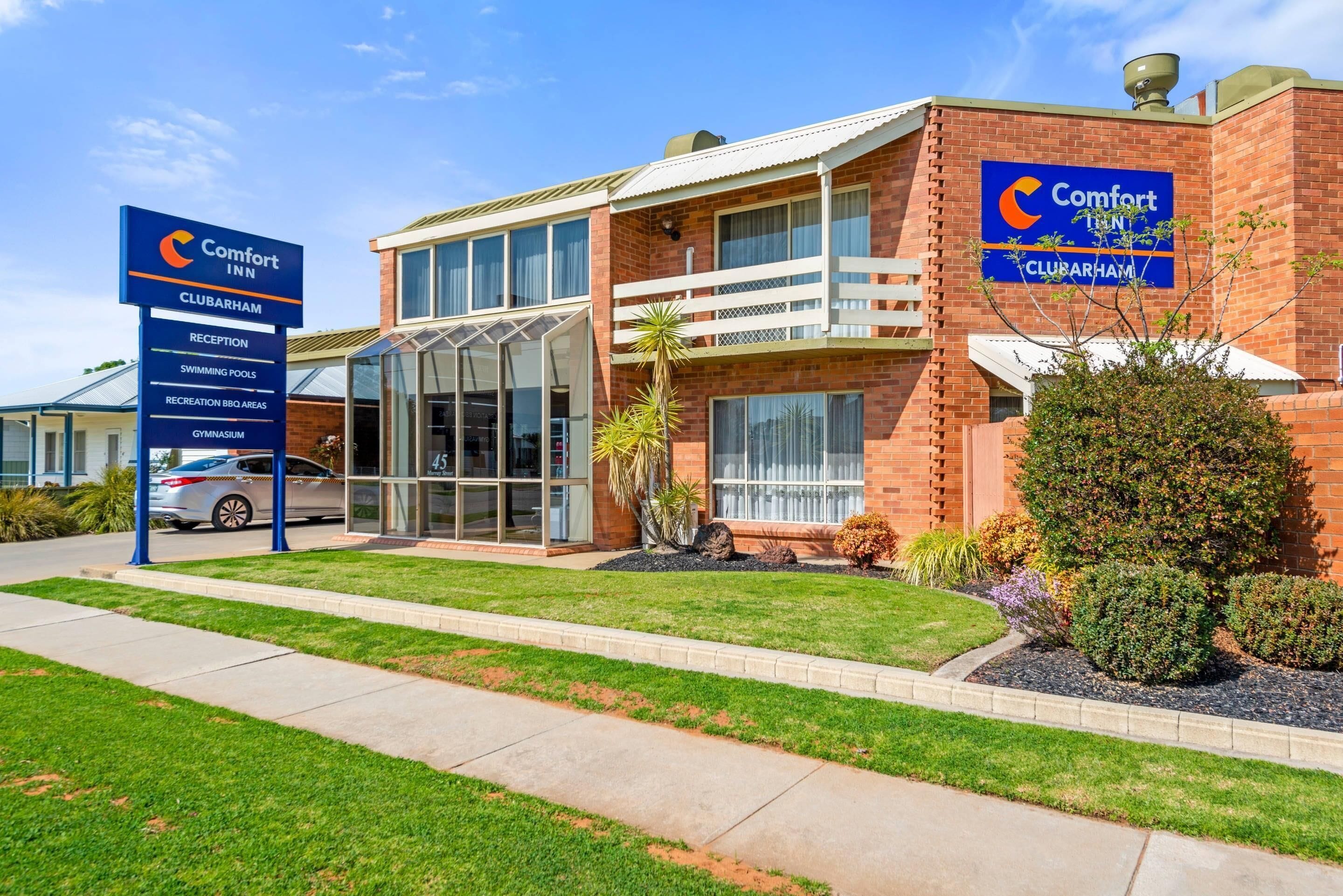Un bâtiment de la chaîne Comfort Inn Clubham comprenant une réception, des piscines, des espaces de loisirs avec des barbecues et une salle de sport.