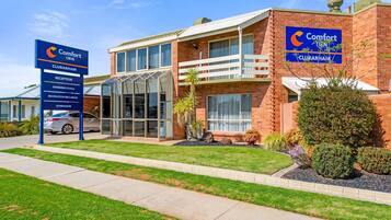 Un bâtiment de la chaîne Comfort Inn Clubham comprenant une réception, des piscines, des espaces de loisirs avec des barbecues et une salle de sport.