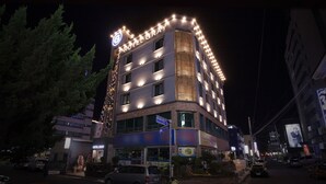 A multi-story hotel with illuminated signage, a visible entrance, and a parking area. - Hotel Gray (Changwon)