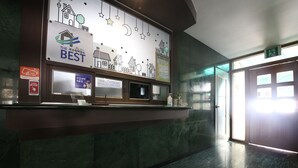 A reception desk with a sign indicating 'The Best' and a 'Cash Receipt' sign. - Bali Motel (Gongju)
