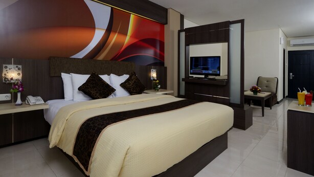 Une chambre d’hôtel moderne équipée d’un grand lit, d’une télévision, d’un bureau et d’une chaise.