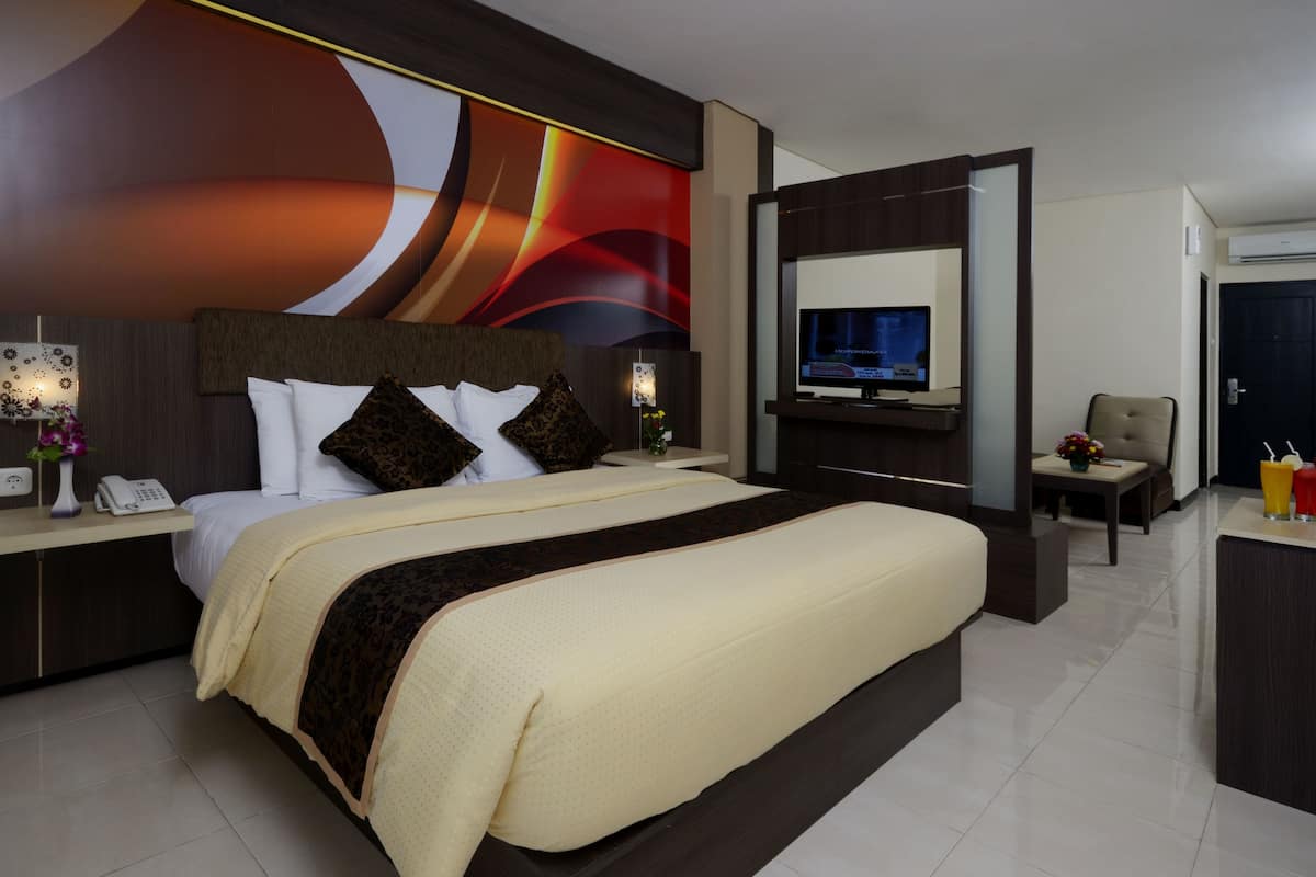 Une chambre d’hôtel moderne équipée d’un grand lit, d’une télévision, d’un bureau et d’une chaise.