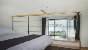 Un dormitorio con una cama grande, una ventana con vistas a un puente y un cabecero de madera.
