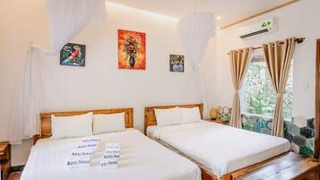Ein Hotelzimmer mit zwei Betten, einer hölzernen Bank und Kunstwerken an den Wänden.