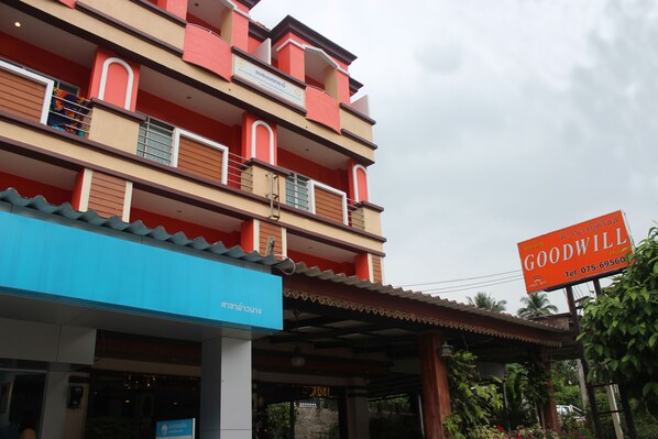 A multi-story building with a prominent "GOODWILL" sign, a blue awning, and a sign indicating a restaurant. - Aonang Goodwill Hotel (Krabi)