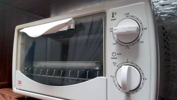 A white microwave oven with a digital display, a timer, and a temperature control knob.