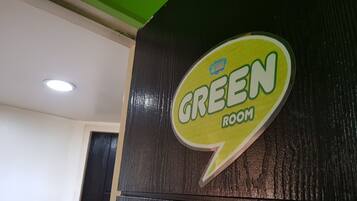 A sign for the GREEN ROOM, indicating a specific area or room within a building.