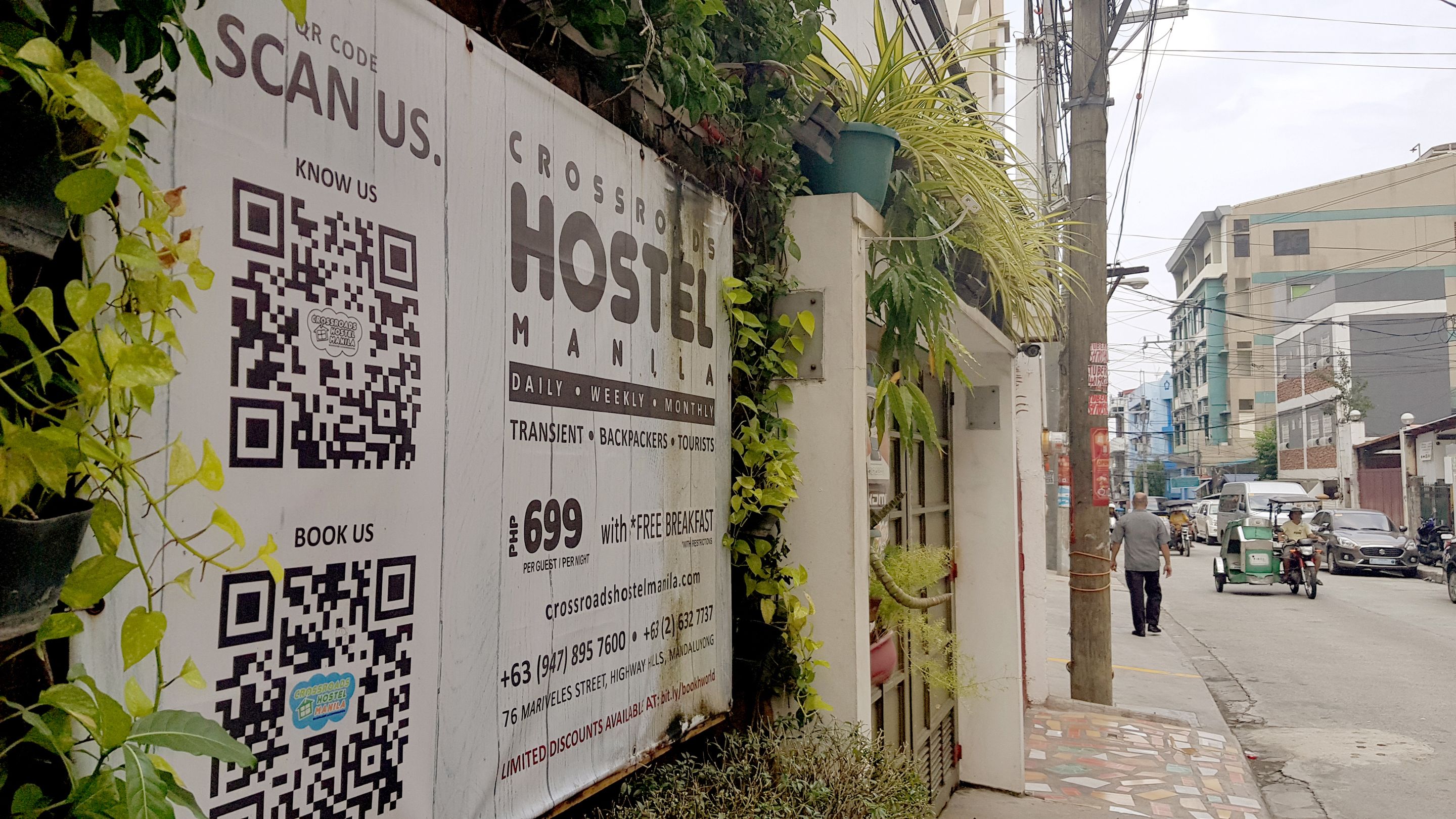 A hostel sign with QR codes and contact information.
