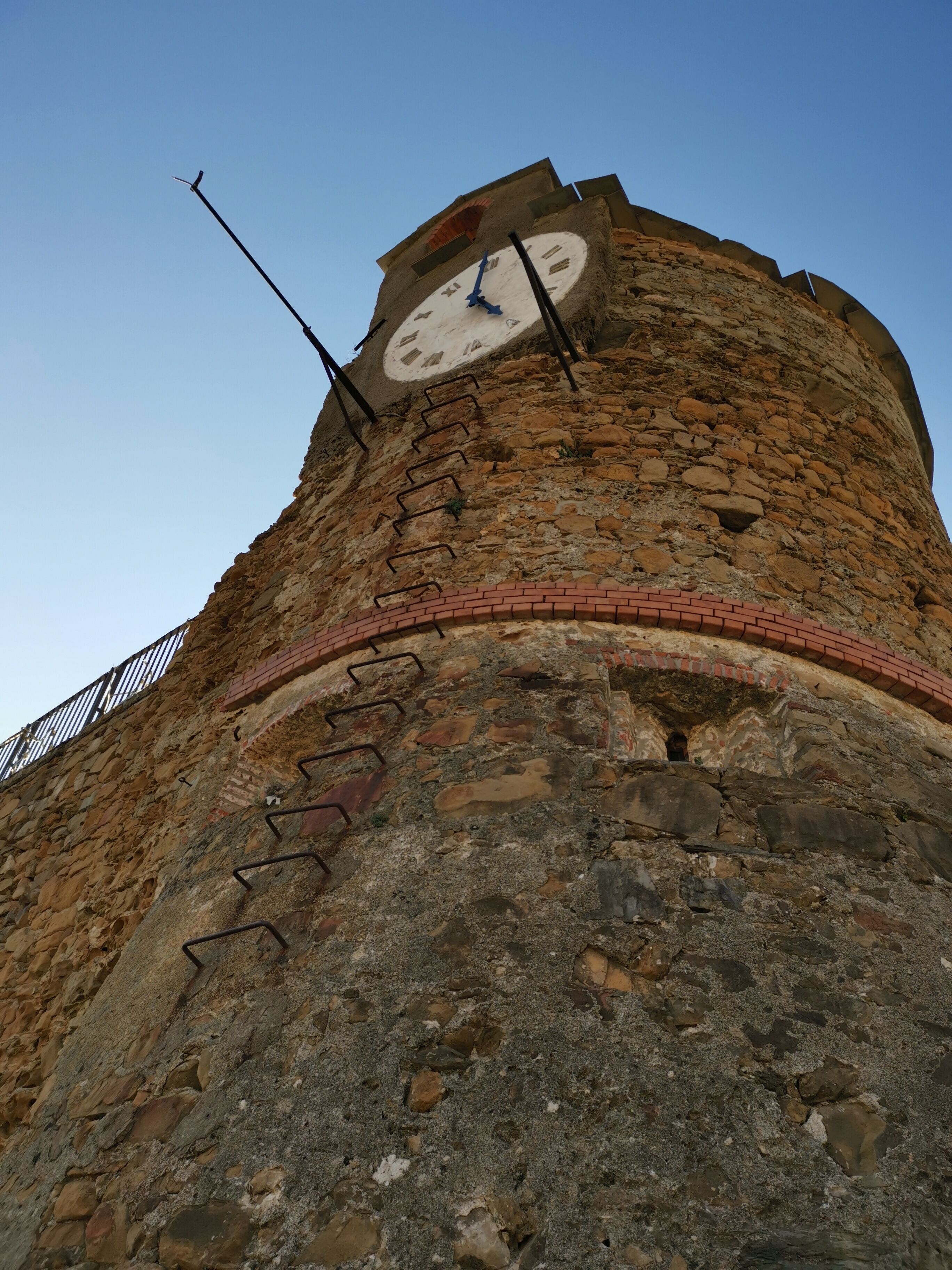 Ein Glockenturm mit einer steinernen Fassade und einem Ziegelsohl.