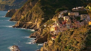 A coastal village with buildings perched on a hillside overlooking the sea. - Il BoMa Affittacamere (Riomaggiore)