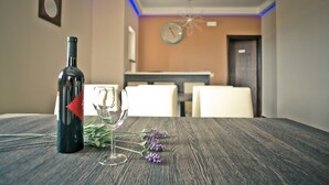 Una mesa de comedor con una botella de vino, una copa de vino y algunas flores.