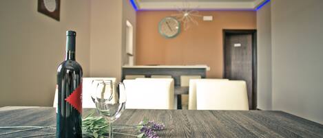 Una mesa de comedor con una botella de vino, una copa de vino y algunas flores.