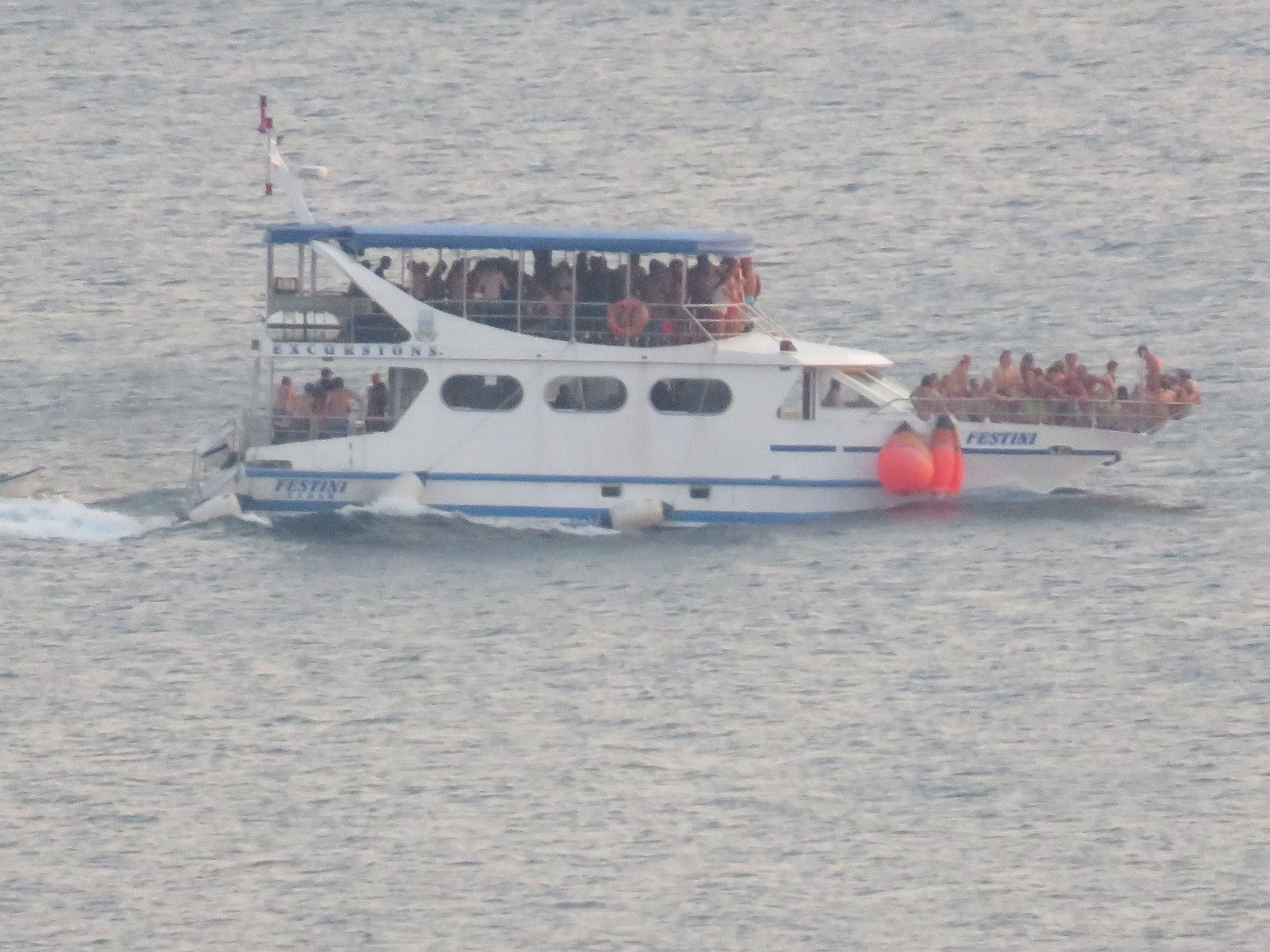 A boat with multiple decks and passengers.