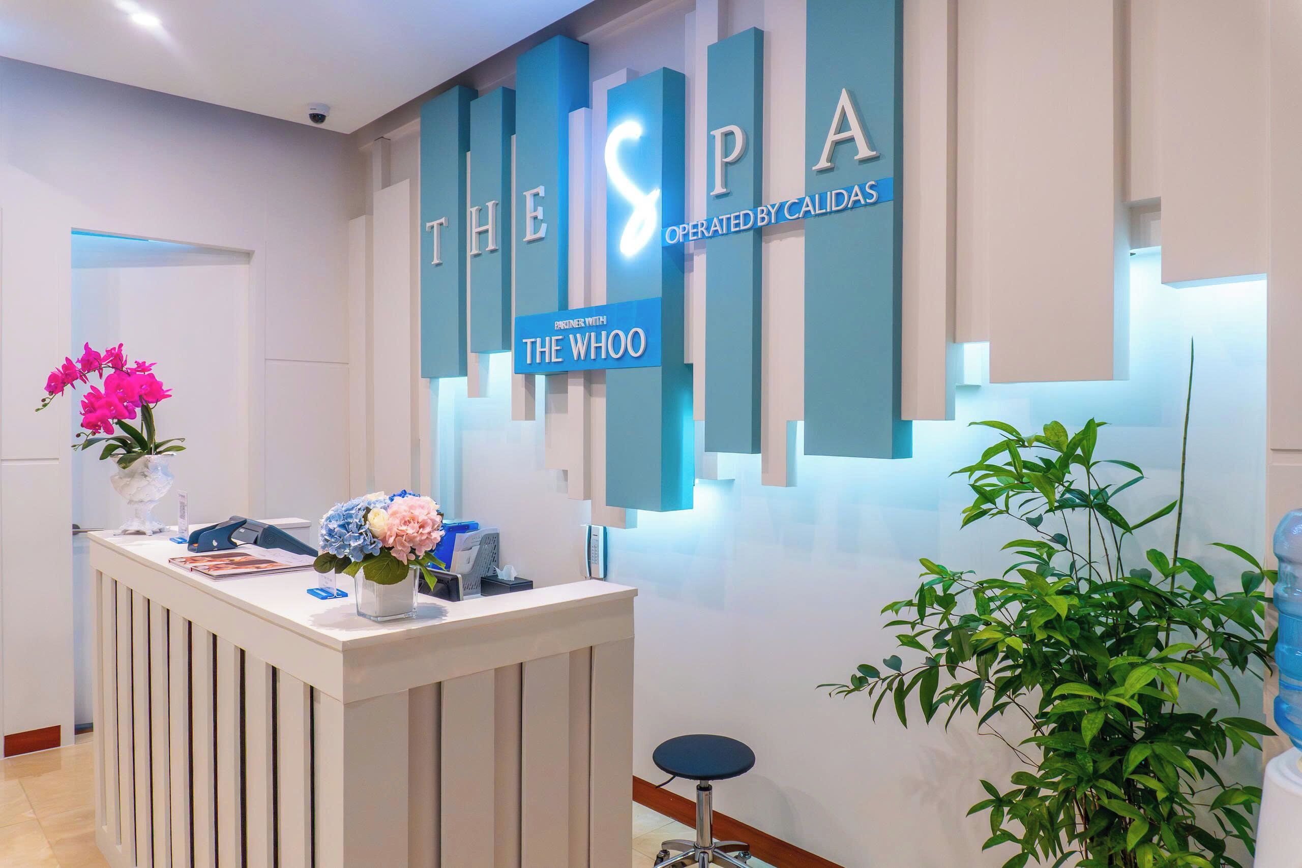 A reception desk with a sign reading 'THE SPA OPERATED BY CALIDAS' and 'PRINER WITH THE WHOO'.
