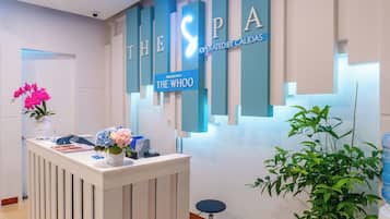 A reception desk with a sign reading 'THE SPA OPERATED BY CALIDAS' and 'PRINER WITH THE WHOO'.