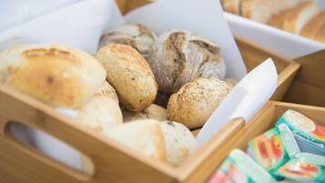 Una caja de madera con diferentes tipos de pan y aperitivos envasados.