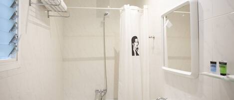 A bathroom with a bathtub, a shower, a sink, and a towel rack.