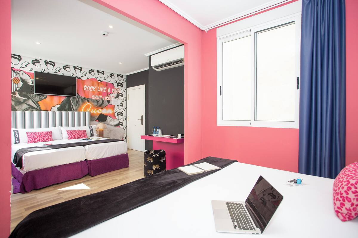 Une chambre moderne avec un lit, un bureau et un ordinateur portable.