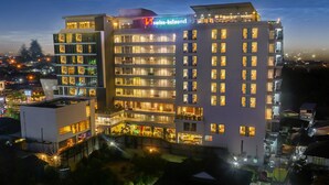 Een hotel met meerdere verdiepingen, in modern design, met een opvallend bord voor Swiss-Belhotel.