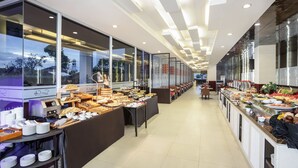 Een moderne hotellobby met een buffetgedeelte met verschillende soorten eten en een zithoek.